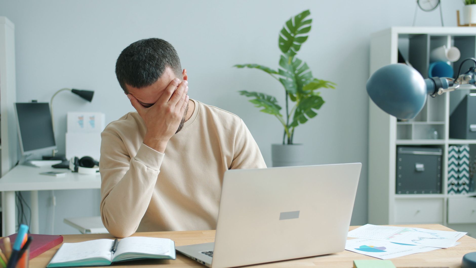 stressed worker at desk with laptop office scene